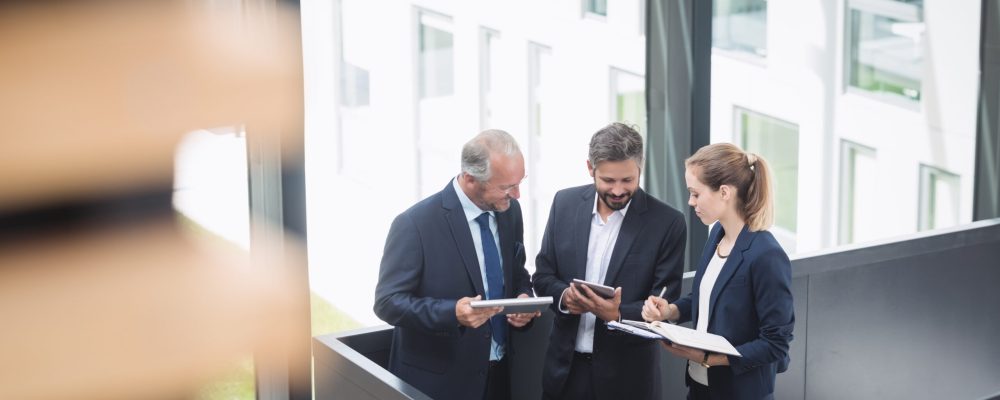 Group of businesspeople having a discussion near staircase in office