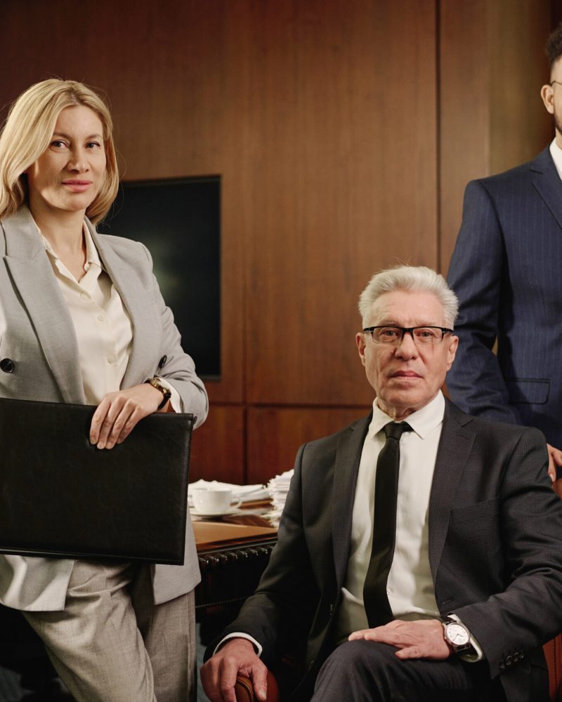 Diverse group of lawyers posing together in office boardroom and smiling at camera