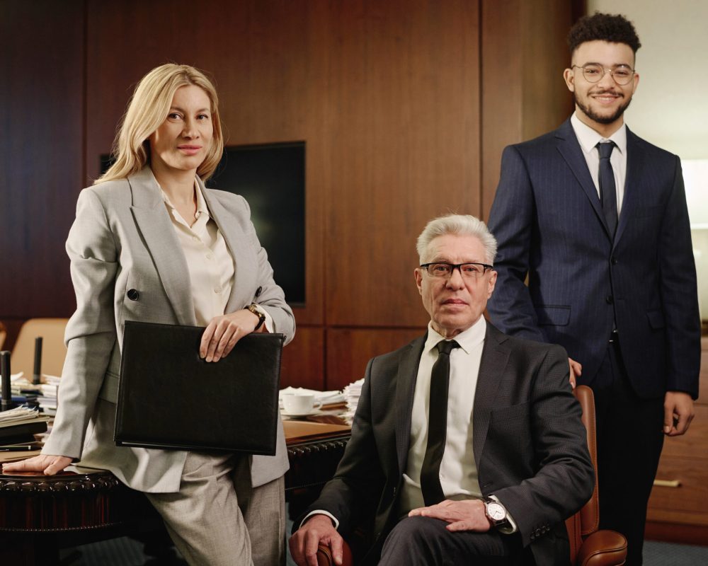 Diverse group of lawyers posing together in office boardroom and smiling at camera